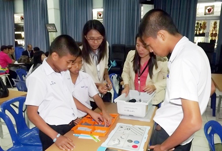 Teachers and students begin the process of learning how to assemble a robot.